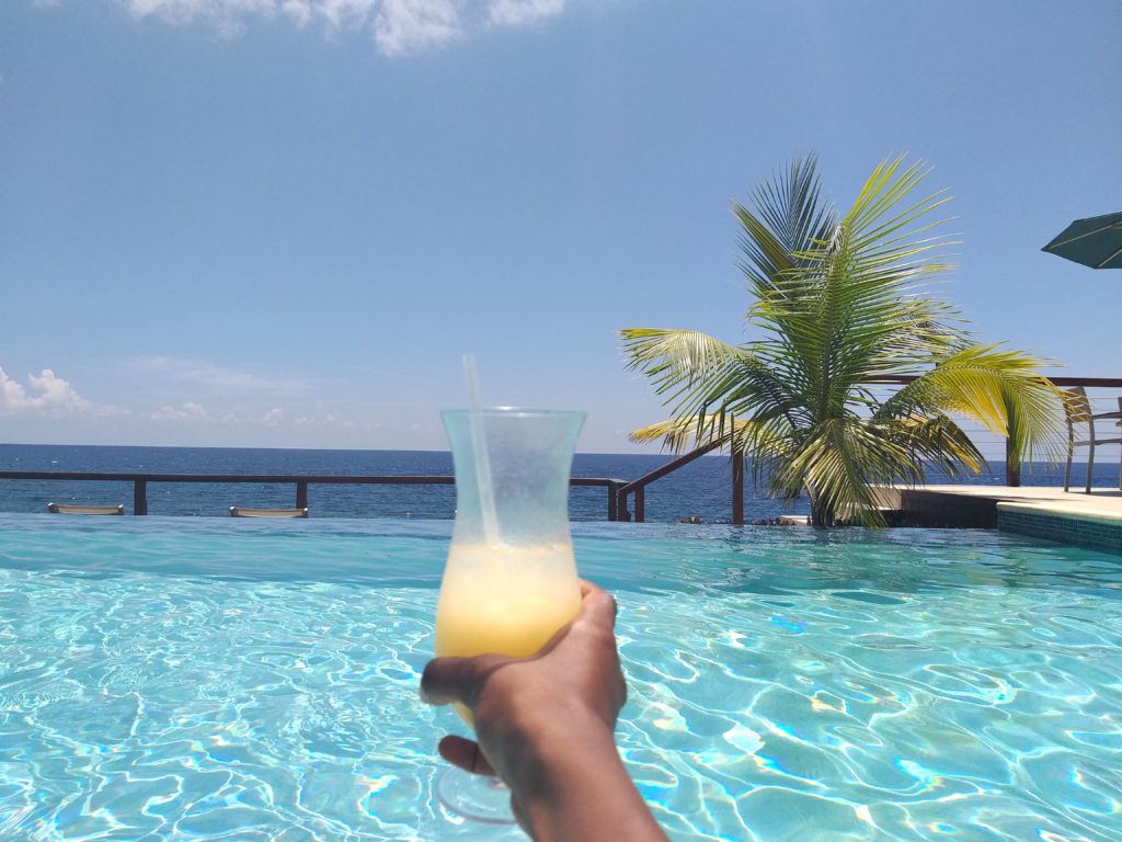 sipping caribbean pina colada cocktail at a luxury hotel in front of the pool