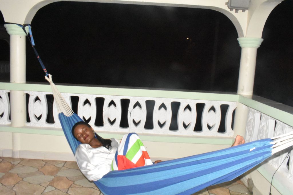Black female traveler laying on a hammock in the Caribbean