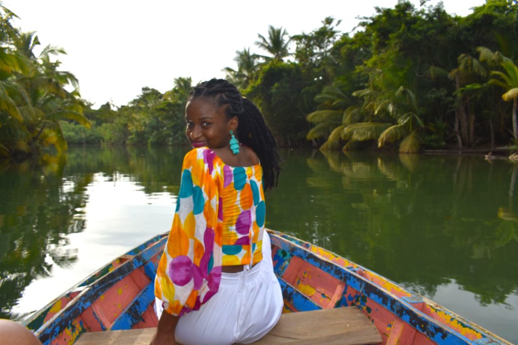 black girl with braids exploring dominica on a boat for dominica tourism