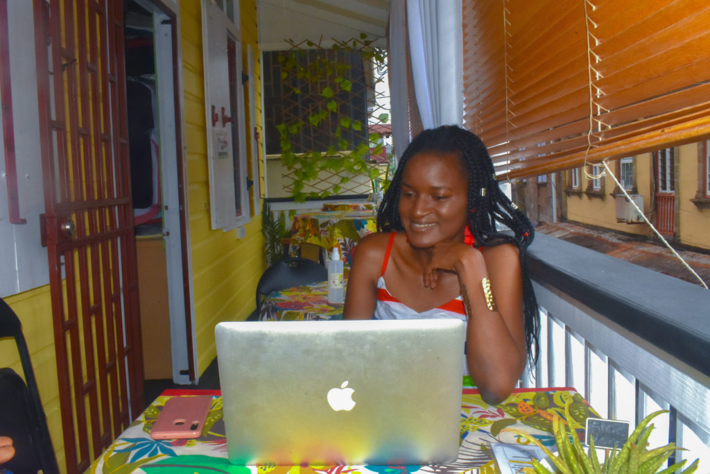 Cutest cafes for remote work, work from anywhere in the Caribbean, Dominica. Black girl working with Macbook
