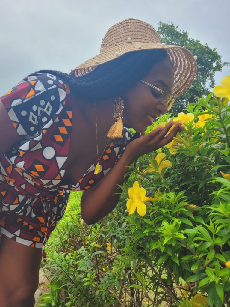 Caribbean eco resort in Dominica: Rosalie bay Ecoresort and Spa. A beautiful girl smelling an alamanda flower in the garden
