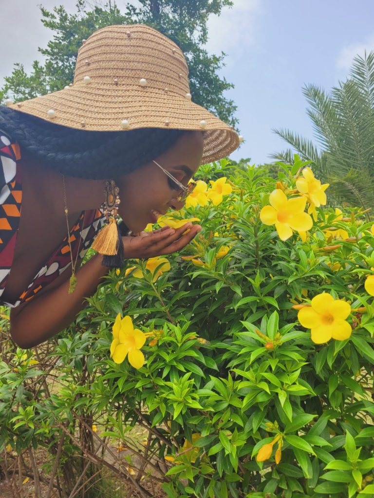 Caribbean eco resort in Dominica: Rosalie bay Ecoresort and Spa. A beautiful girl smelling an alamanda flower in the garden