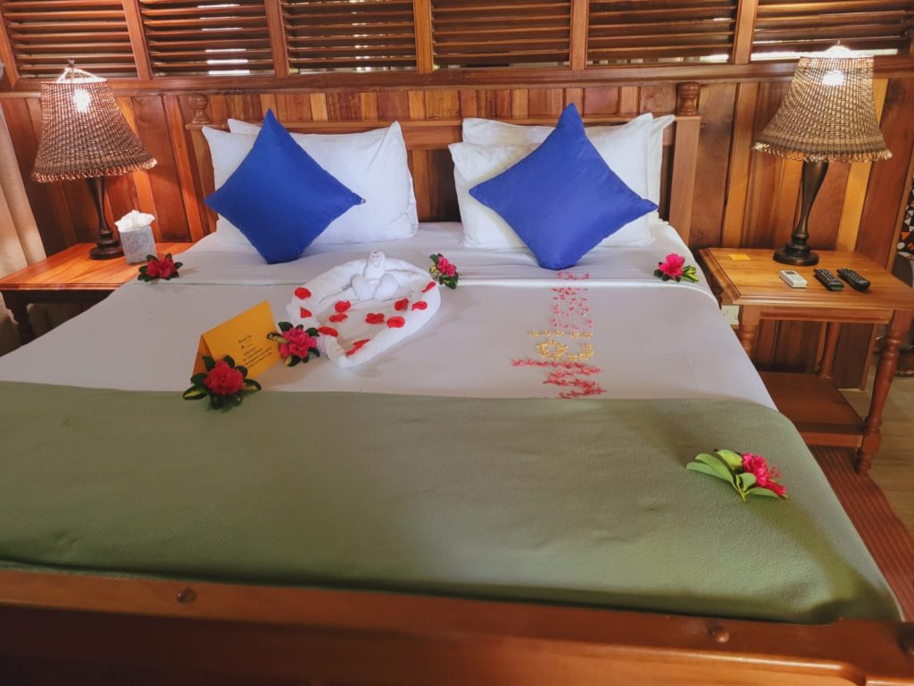 Caribbean eco resort in Dominica: Rosalie bay Ecoresort and Spa. A bed with a pink hibiscus flower