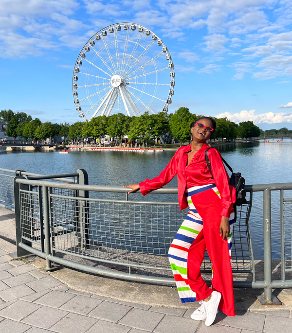 Travel with Clem in front of "La Grande Roue de Montreal" in the summer, during a Montreal travel experience 