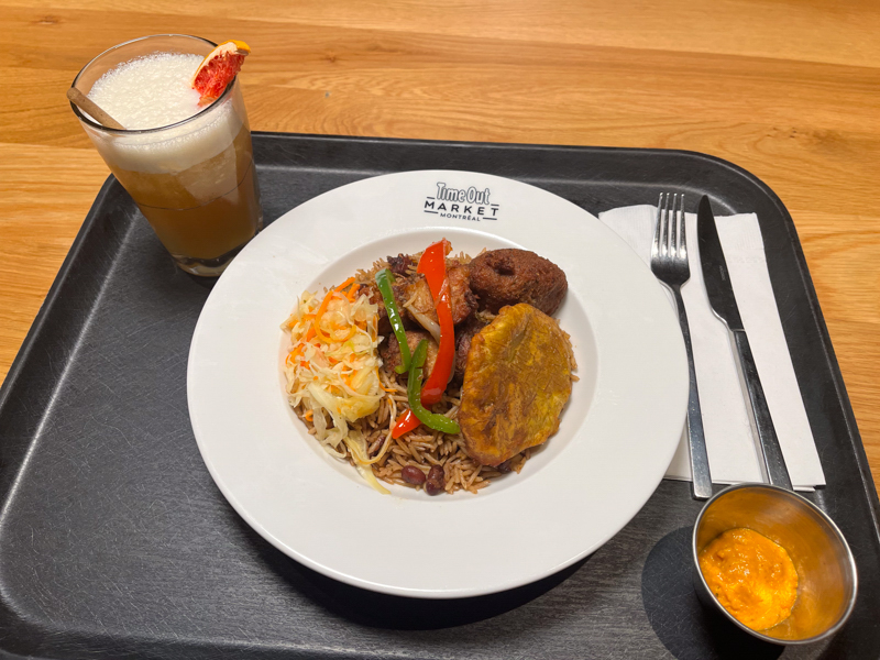 Eating authentic Haitian food at the Time Out Market in Montreal during a Montreal travel experience in the summer 