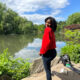 Beautiful black girl wearing a red HM sweater and standing at central park
