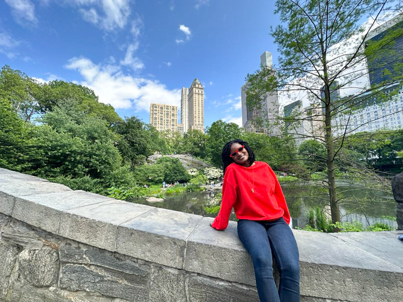 Things to do in New York City alone - beautiful black girl wearing a red sweater and spending some time at Central park