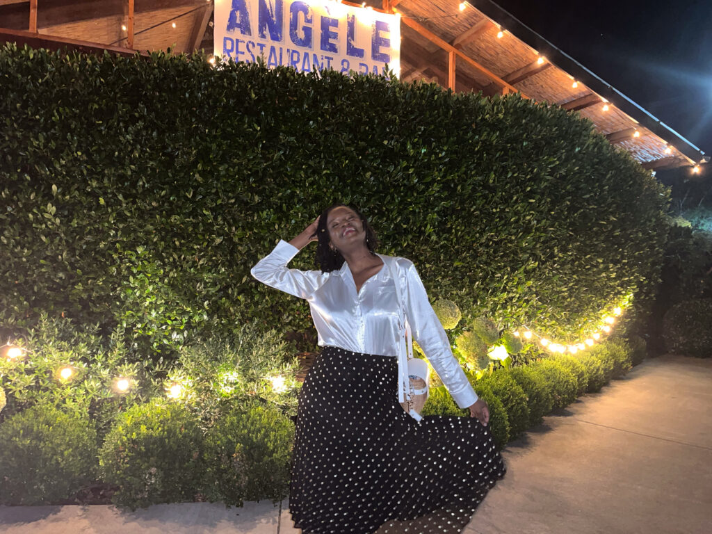 Travel with Clem posing in front of the sign Chez Angele, one of the top restaurants downtown Napa for authentic french cuisine