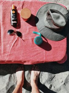 beach essentials - sunglasses, sunscreen and a hat