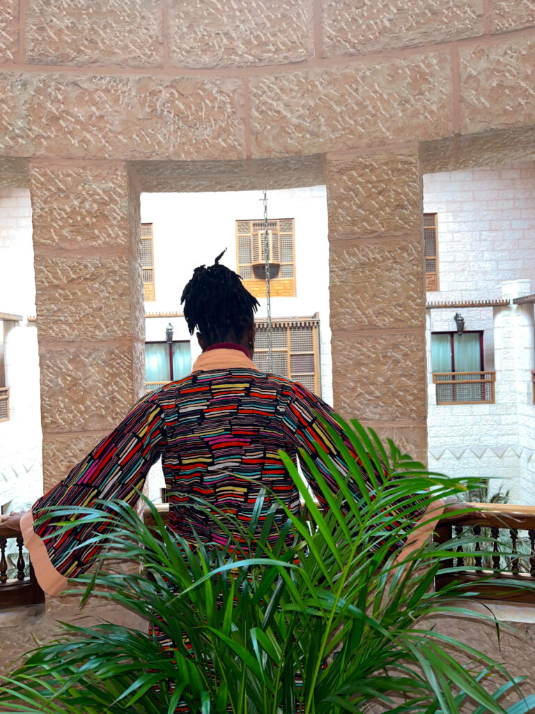 Bible verses about safety - Black girl wearing a Ngaska coat or colorful Kimono, posing in the Movenpick Petra hotel