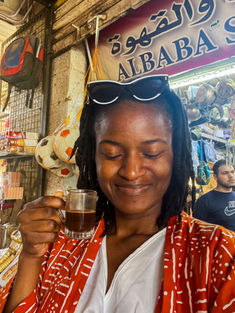 Travel with Clem, Cameroonian Influencer based in Canada tasting local coffee at a souk in Aqaba, Jordan