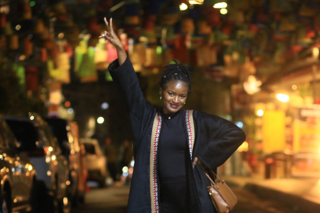What to wear in Jordan - Black girl, Travel with Clem wearing a beautiful black bedouin coat in the middle of Rainbow street downtown Amman