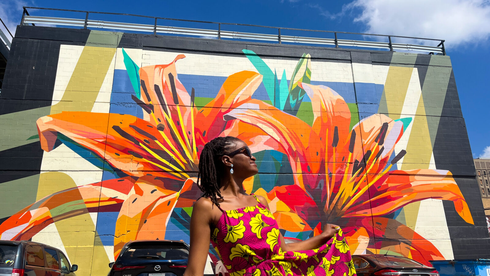 Standing in front of a beautiful flower mural in Saskatoon